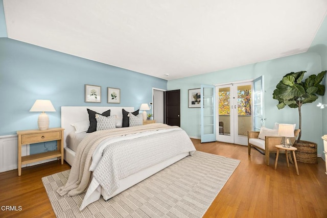 bedroom with french doors, wood-type flooring, and access to outside