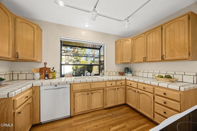 kitchen featuring dishwasher, tile counters, light brown cabinets, sink, and light hardwood / wood-style flooring