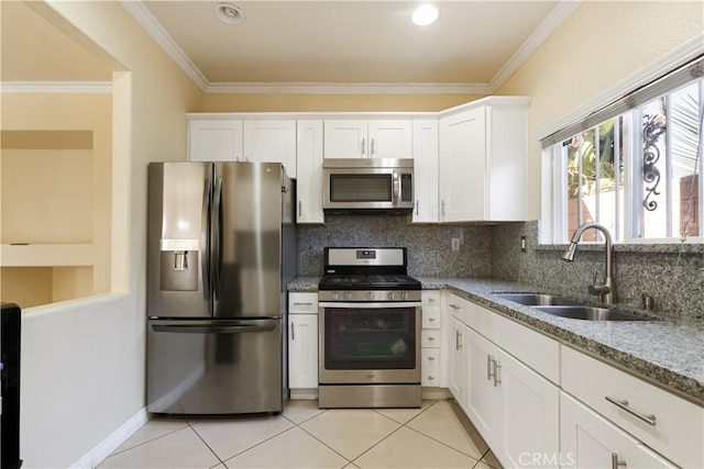 kitchen featuring appliances with stainless steel finishes, light stone counters, sink, white cabinetry, and light tile patterned flooring