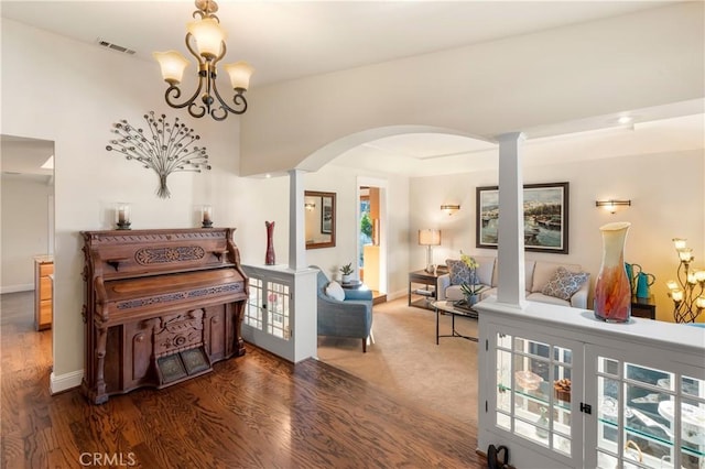 misc room featuring dark wood-type flooring and an inviting chandelier