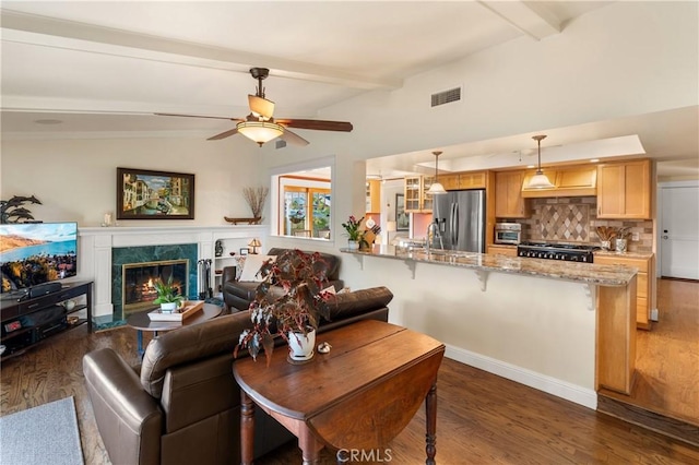 living room featuring ceiling fan, lofted ceiling with beams, sink, dark wood-type flooring, and a high end fireplace