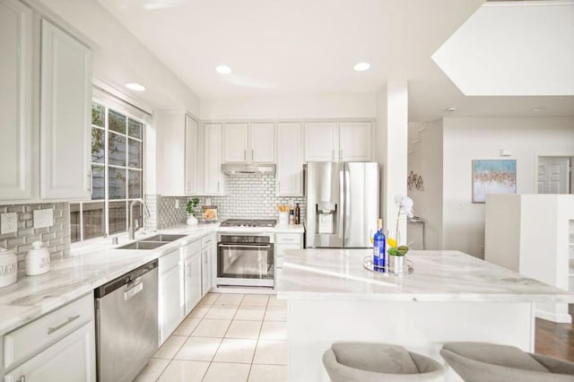 kitchen with appliances with stainless steel finishes, white cabinetry, and sink