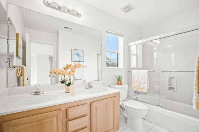 full bathroom with combined bath / shower with glass door, vanity, tile patterned floors, and toilet