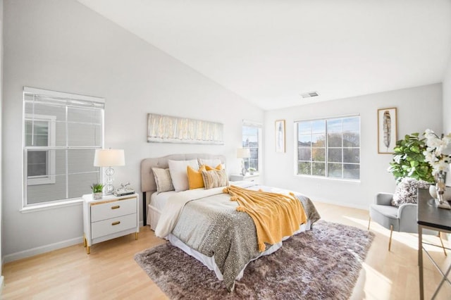 bedroom with lofted ceiling and light hardwood / wood-style floors