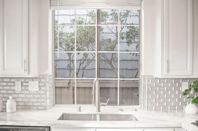 details featuring sink, white cabinetry, dishwasher, and light stone counters