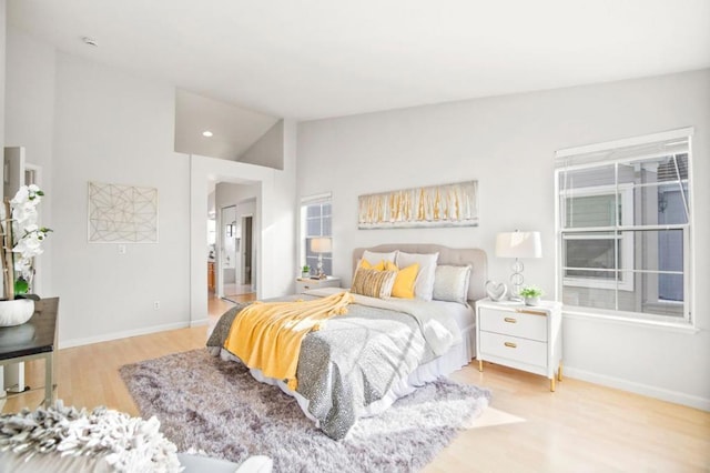 bedroom with light hardwood / wood-style flooring and vaulted ceiling