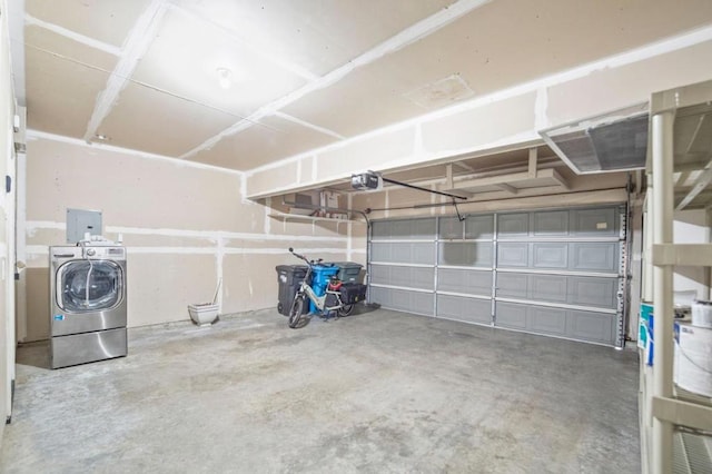 garage with a garage door opener and washer and dryer