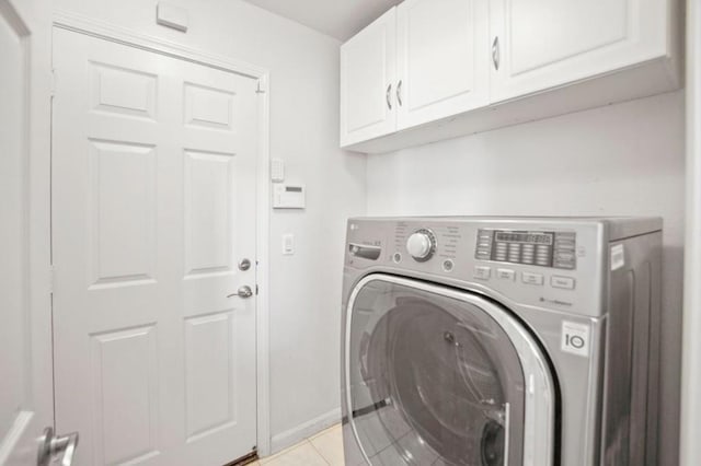 laundry room with cabinets, washer / dryer, and light tile patterned flooring