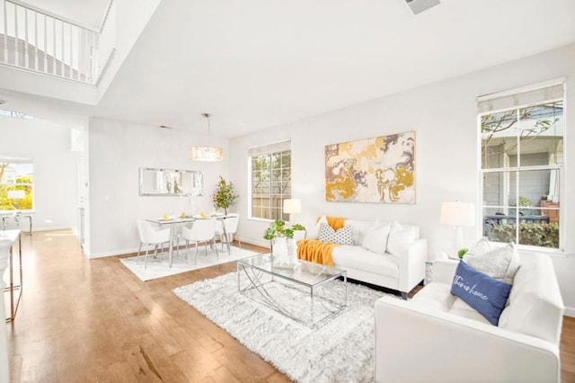 living room featuring a towering ceiling and wood-type flooring