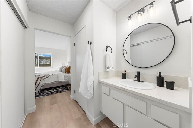 bathroom with a textured ceiling, vanity, and hardwood / wood-style flooring