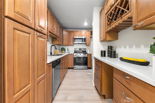 kitchen with stainless steel appliances, sink, and light wood-type flooring