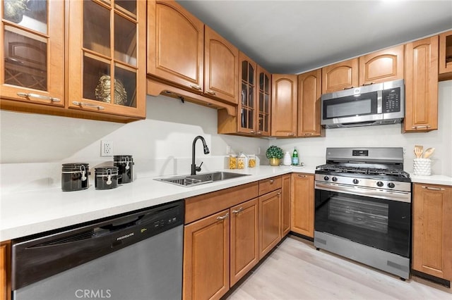 kitchen featuring appliances with stainless steel finishes, light wood-type flooring, and sink