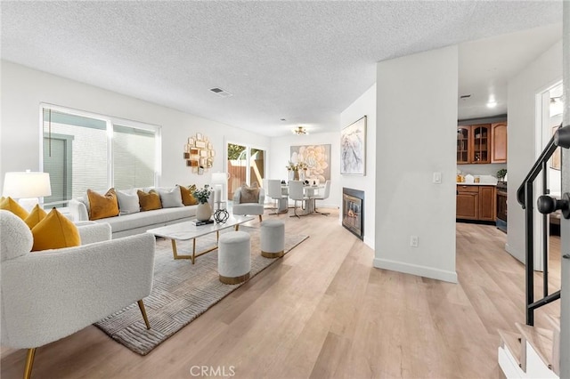 living room with light wood-type flooring and a textured ceiling