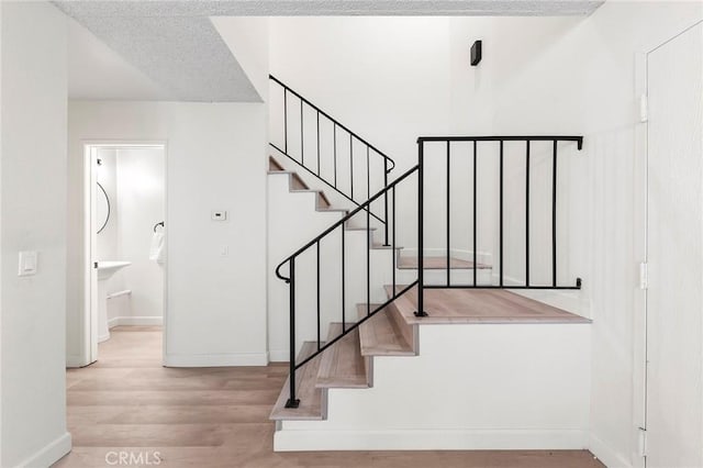 staircase with hardwood / wood-style flooring