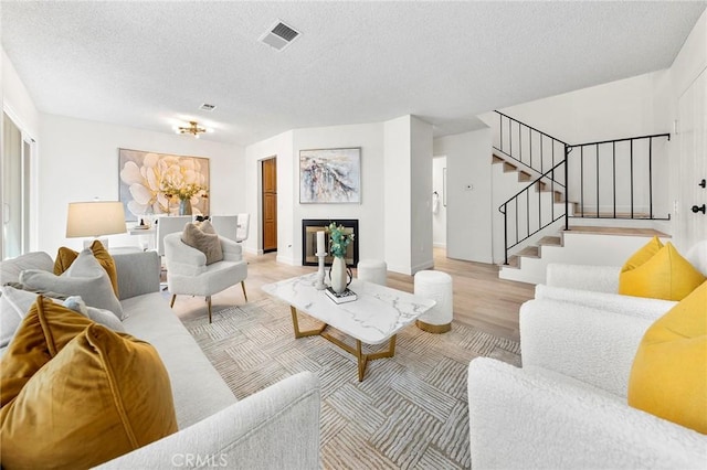 living room featuring a textured ceiling and light wood-type flooring