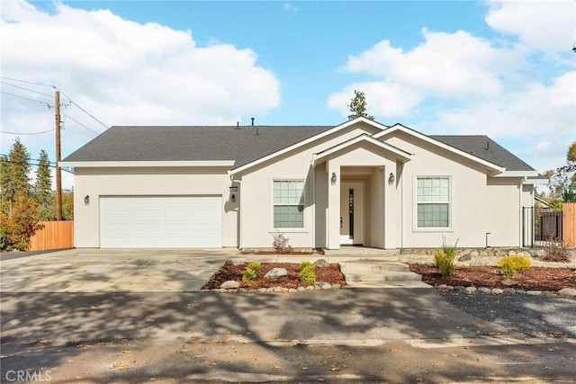 ranch-style home featuring driveway, an attached garage, fence, and stucco siding