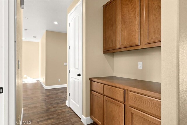 corridor with dark hardwood / wood-style flooring