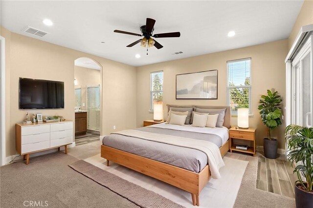 carpeted bedroom featuring ensuite bathroom and ceiling fan