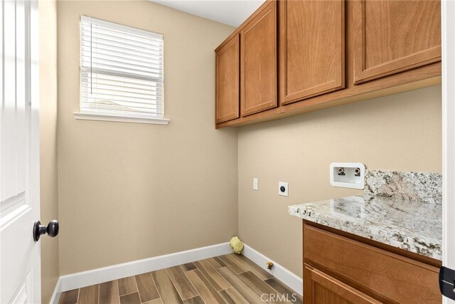 washroom featuring hardwood / wood-style flooring, cabinets, hookup for an electric dryer, and washer hookup