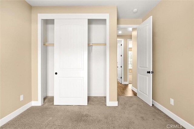 unfurnished bedroom featuring light colored carpet and a closet