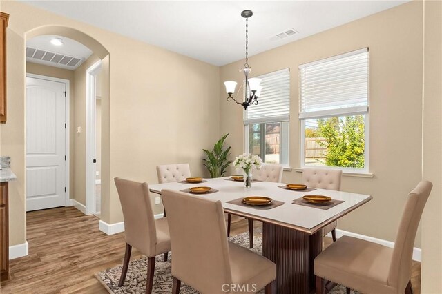 dining area featuring a notable chandelier and light hardwood / wood-style flooring