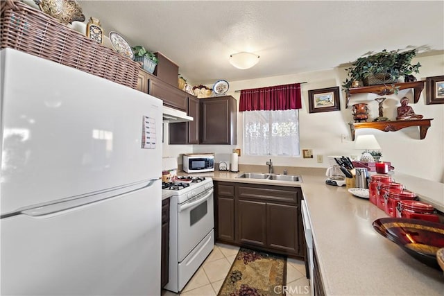 kitchen featuring sink, white appliances, dark brown cabinets, and light tile patterned flooring