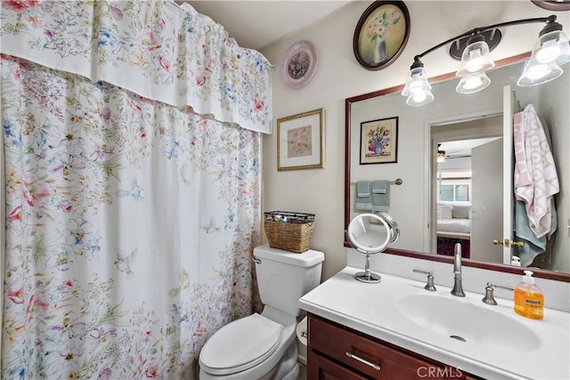 bathroom with toilet, a shower with shower curtain, and vanity