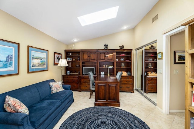 tiled office featuring vaulted ceiling with skylight