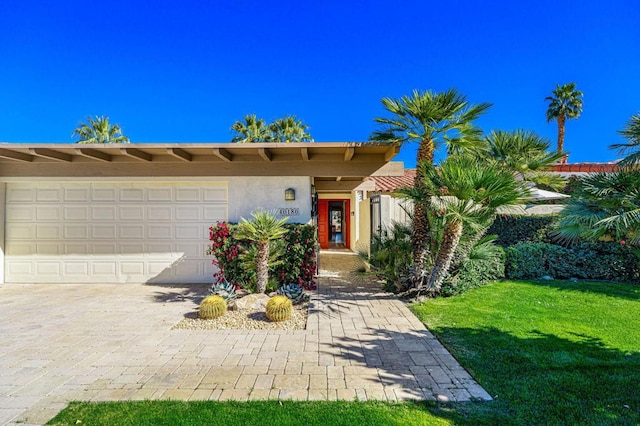 view of front of home featuring a front yard and a garage