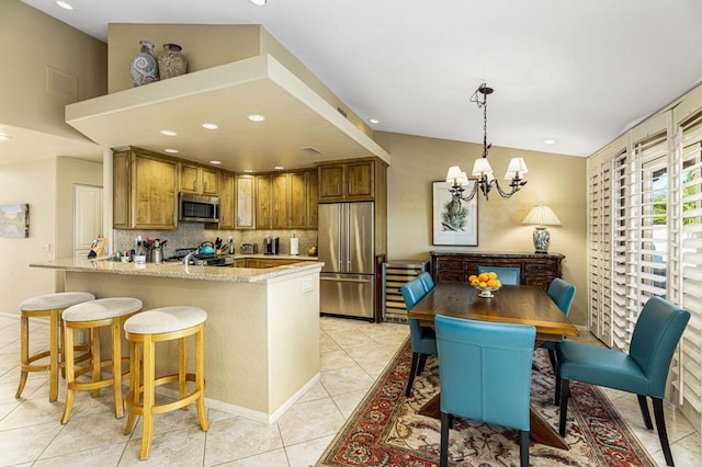 kitchen with hanging light fixtures, a notable chandelier, light tile patterned floors, backsplash, and appliances with stainless steel finishes