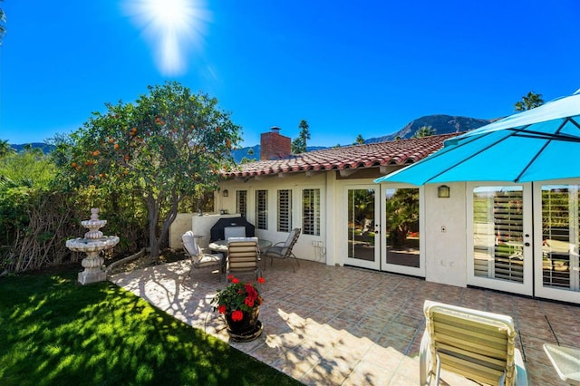 back of house featuring a patio area, french doors, and a mountain view