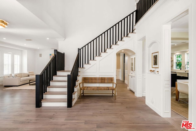 staircase featuring crown molding and hardwood / wood-style flooring