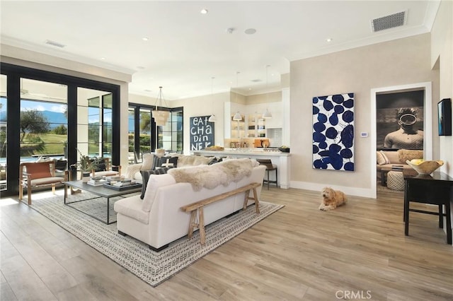 living room featuring crown molding and light hardwood / wood-style flooring