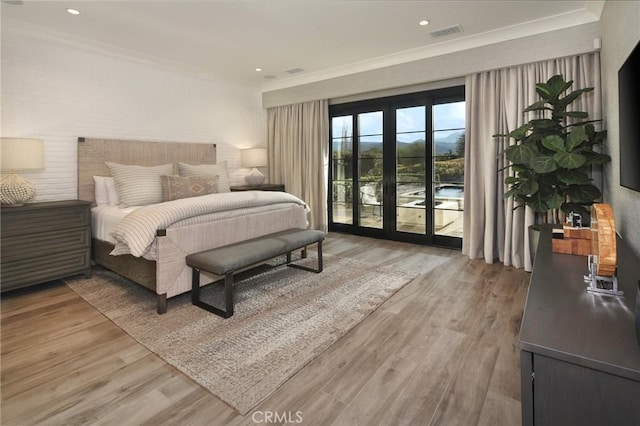 bedroom featuring access to exterior, crown molding, hardwood / wood-style floors, and french doors