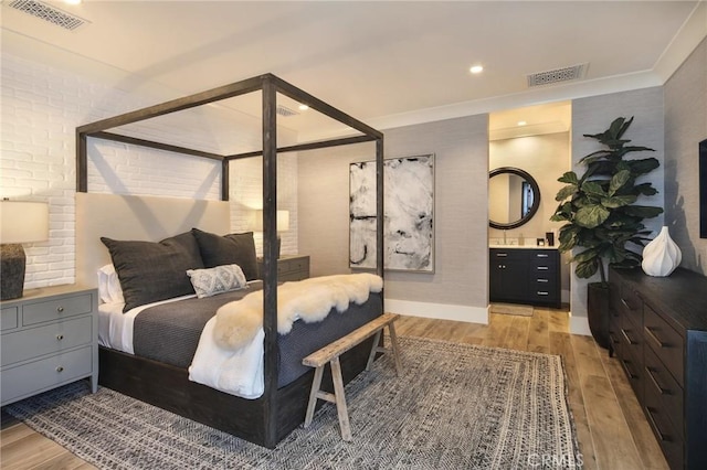 bedroom with crown molding and light hardwood / wood-style flooring