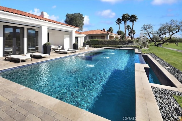 view of swimming pool featuring pool water feature and a patio