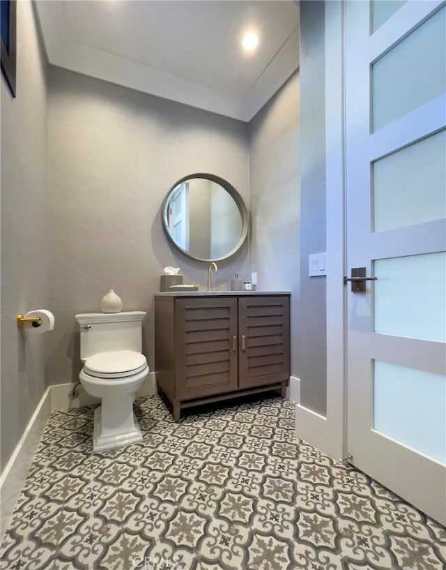 bathroom featuring ornamental molding, vanity, and toilet