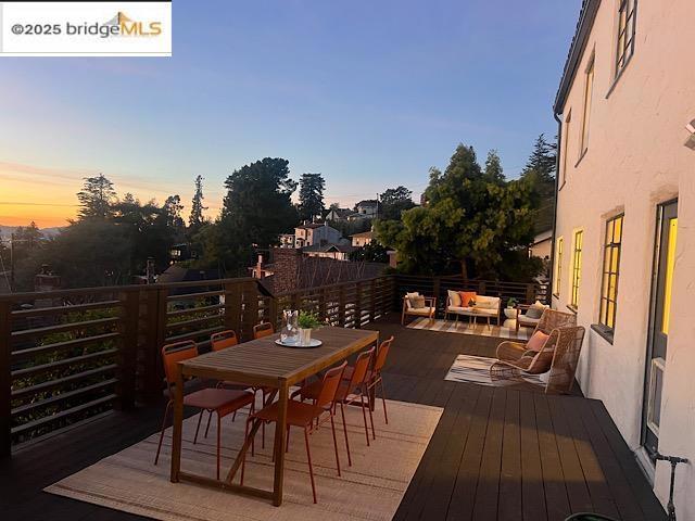 deck at dusk with an outdoor hangout area