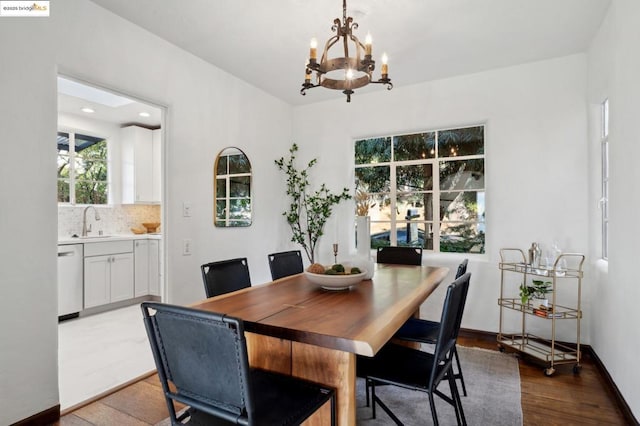 dining space featuring sink, an inviting chandelier, and light hardwood / wood-style floors