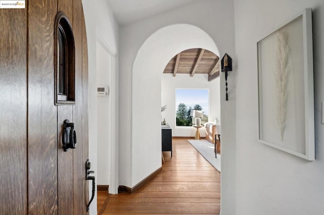 hallway featuring beam ceiling, wood ceiling, and hardwood / wood-style flooring