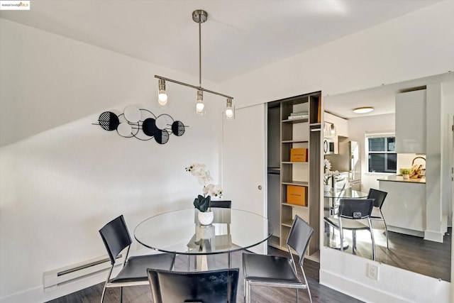 dining area with a baseboard heating unit and dark hardwood / wood-style floors