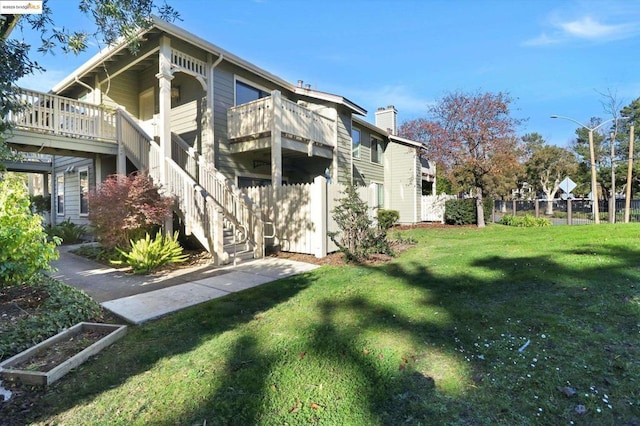 view of home's exterior featuring a balcony and a lawn