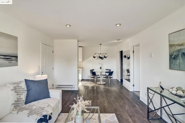 living room featuring dark hardwood / wood-style flooring, a baseboard radiator, and a notable chandelier