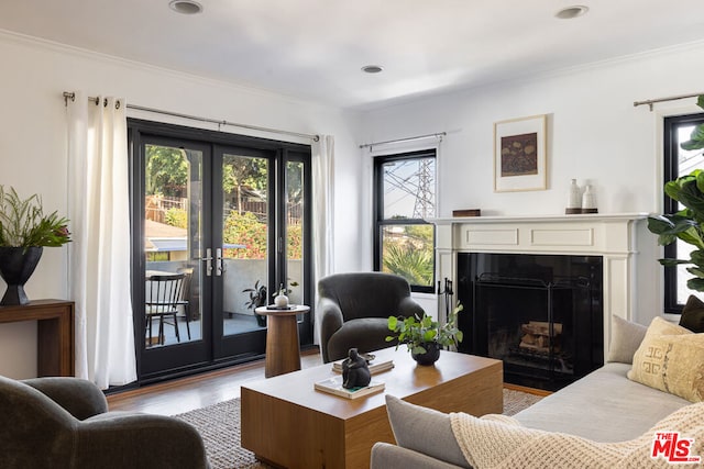 living room with french doors, light hardwood / wood-style floors, and crown molding