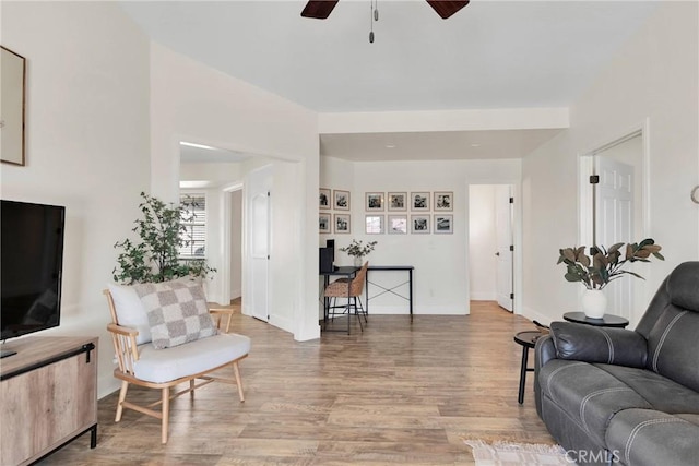 living room featuring ceiling fan and light hardwood / wood-style floors