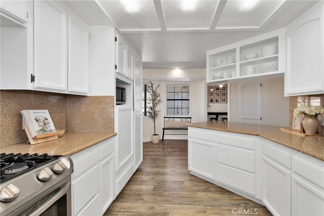 kitchen with light stone countertops, stainless steel range with gas cooktop, tasteful backsplash, white cabinetry, and wood-type flooring