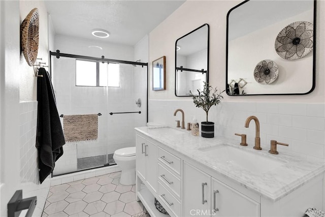 bathroom featuring tile walls, toilet, a shower with shower door, and vanity