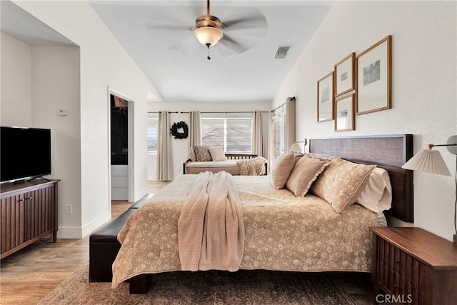 bedroom featuring ceiling fan, vaulted ceiling, and light hardwood / wood-style flooring