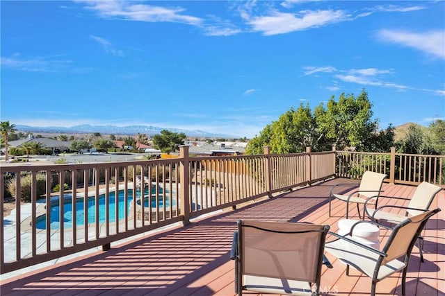 deck featuring a fenced in pool and a mountain view