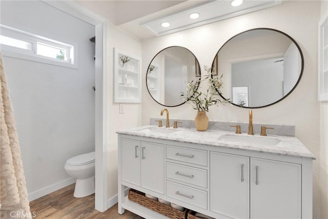 bathroom with toilet, vanity, and hardwood / wood-style floors